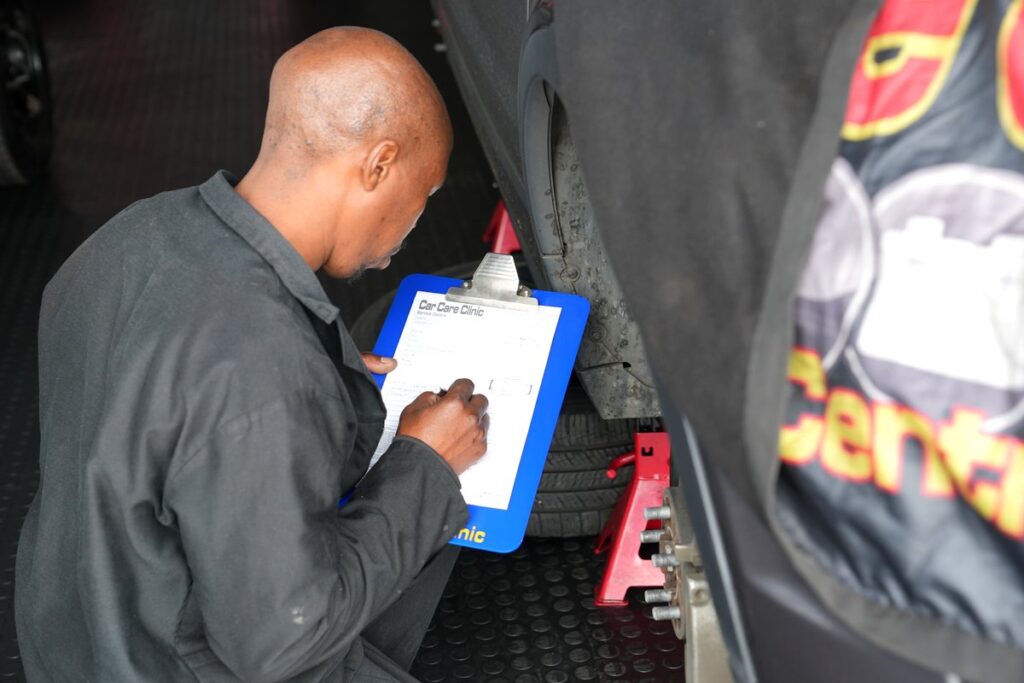 Technician filling in the 76 point safety check sheet at Car Care Clinic, The Square Sunninghill