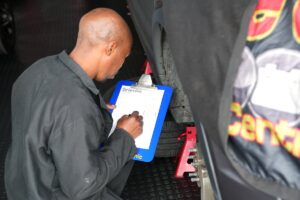 Technician filling in the 76 point safety check sheet at Car Care Clinic, The Square Sunninghill
