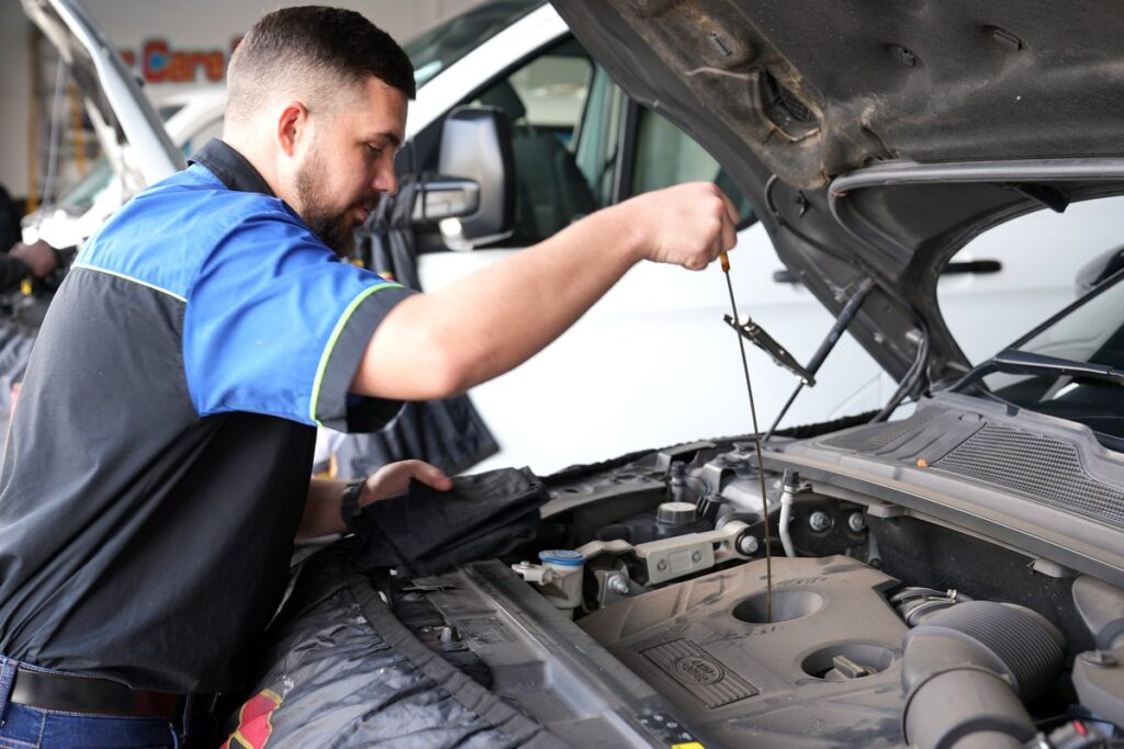 Technician checking the engine oil dipstick at Car Care Clinic, The Square Sunninghill