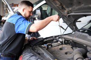 Technician checking the engine oil dipstick at Car Care Clinic, The Square Sunninghill